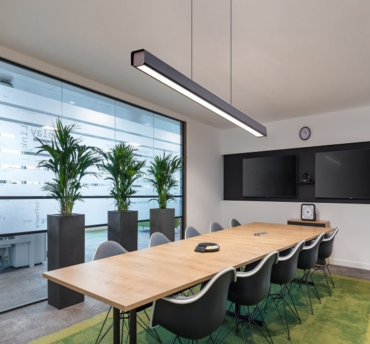 Modern office room with a suspended rectangular LED chandelier above the table.