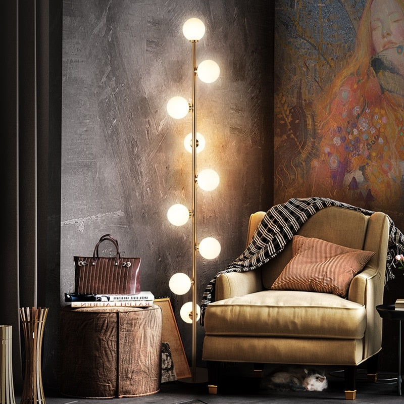 Lights of Scandinavia - Nucleic - Modern LED standing lamp with frosted glass ball fixtures. Nickel gold plated steel body. Suitable for bedrooms, halls or next to a lonely wall. 9 light sources with a coverage of approximately 6-12 square meters, using the included LED Bulbs. Base diameter: 25cm Glass ball diameter: 10cm Specifications Light Source 9x LED Bulbs Base Type G4 Power Consumption 16-20W Is Bulbs Included Yes Dimmable