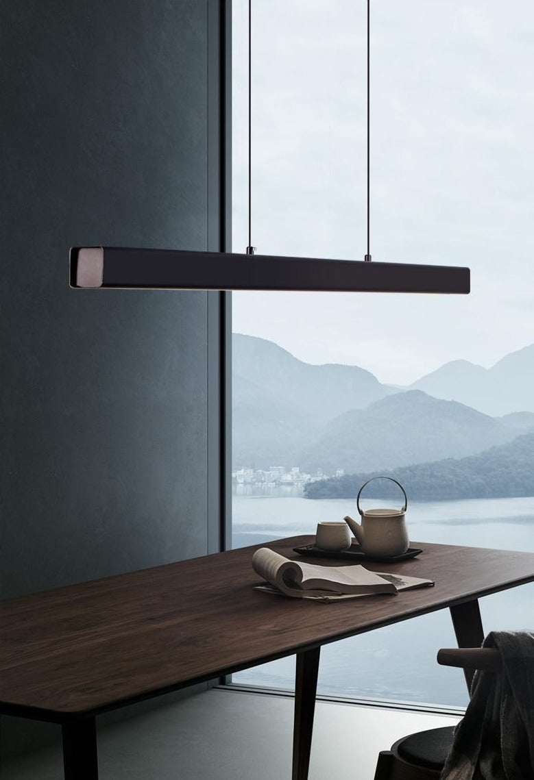 Modern rectangular LED chandelier suspended above a wooden dining table in a contemporary interior.