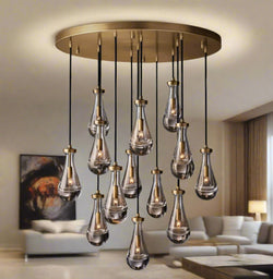 Raine Modern Chandelier with K9 crystal prisms and sleek metal design, perfect for high-ceiling living rooms, foyers, and upscale interiors. Adjustable height, energy-efficient LED compatible.