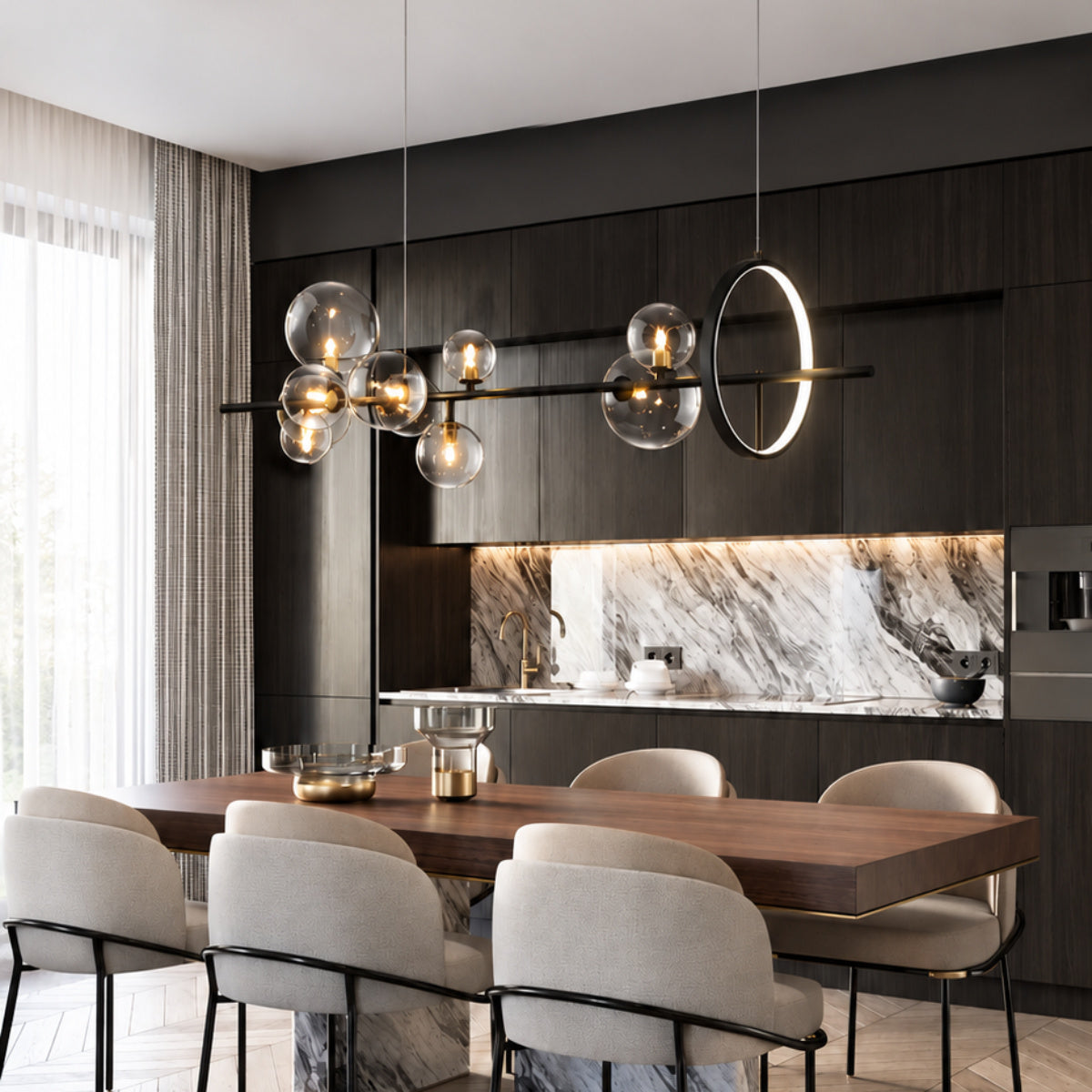 Modern dining room with a long wooden table, six upholstered dining chairs, and a large linear pendant light with multiple clear glass bubble globes and a circular ring light hanging above. The background features dark wood cabinetry, a white and gray marble backsplash, and a large window with sheer curtains.